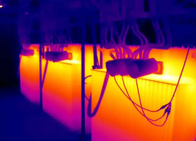 Thermal image of electrical cabinets and wiring showing hot spots on panels and cables.